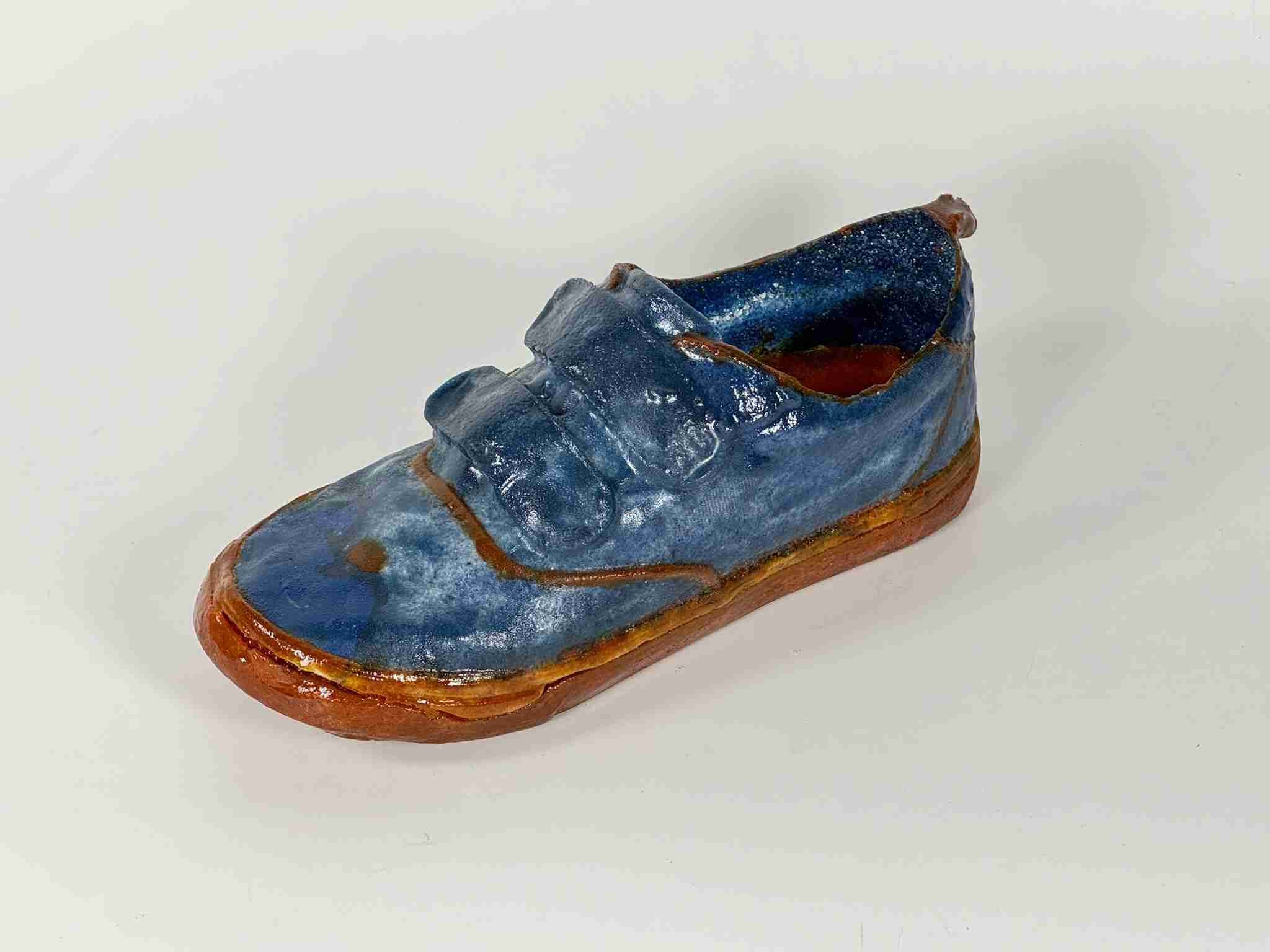 blue sneaker with velcro and orange sole